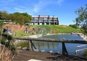 a building on top of a hill next to a pond at Lofts - Club de campo San Pedro in San Pedro