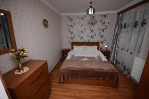 een slaapkamer met een bed en een vaas met bloemen bij Villa Lazika in Borjomi