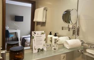 bagno con bancone, specchio e lavandino di Hotel Tari a Würzburg