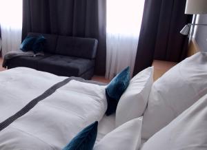 a hotel room with a bed with pillows and a chair at Hotel Tari in Würzburg