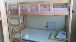 a bunk bed room with two bunk beds and a ladder at Kangguan Guesthouse in Tongyeong
