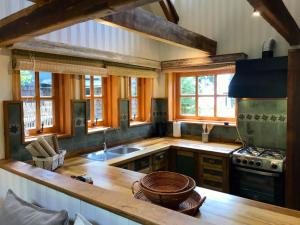 a large kitchen with wooden counters and windows at Cabañas Quebrada Verde in Puerto Varas