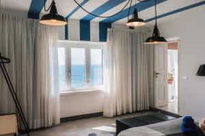 - une chambre avec des bandes bleues et blanches au plafond dans l'établissement La Concha Suites, à Pioppi