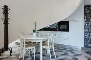 une salle à manger avec une table et des chaises blanches dans l'établissement La Concha Suites, à Pioppi