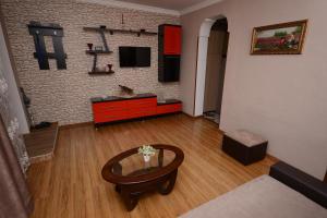 een woonkamer met een tafel en een televisie bij Villa Lazika in Borjomi