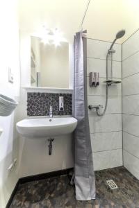 biała łazienka z umywalką i prysznicem w obiekcie Apartment 229 w Dortmundzie