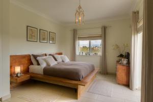 een slaapkamer met een groot bed en een raam bij Casa Marinha Beach in Lagoa +11 foto's