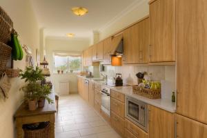 a large kitchen with wooden cabinets and a counter at Casa Marinha Beach in Lagoa