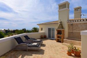 een patio met stoelen en een open haard op een dak bij Casa Marinha Beach in Lagoa