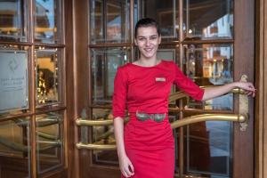 a woman in a red dress standing in front of a door at Kempinski Hotel Grand Arena Bansko in Bansko +37 photos