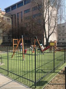 a playground in a park with children on swings at Apartament Karmelicka 11 in Warsaw