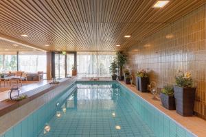 ein Pool in einem Gebäude mit einer großen Decke in der Unterkunft Hotel Fjalar in Salo