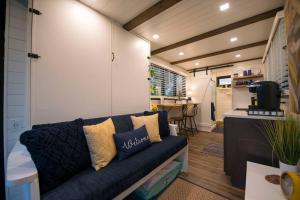 een woonkamer met een bank en een tafel bij Elegant Container Tiny House Yellow & Blue in Waco