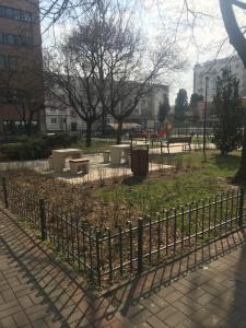 a fence in a park with benches and trees at Apartament Karmelicka 11 in Warsaw