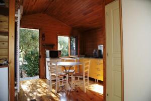 una cucina con tavolo e sedie in una cabina di GITES de Plos Appart CHALET PISCINE SPA ad Anduze