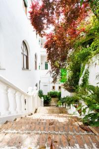 una escalera que conduce a un edificio blanco con árboles en Hotel España, en Lanjarón