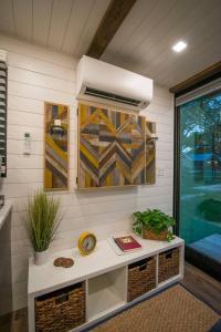 a room with a table with a clock and a window at Elegant Container Tiny House Yellow & Blue in Waco