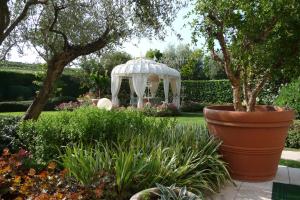 einen weißen Pavillon in einem Garten mit Pflanzen in der Unterkunft Resort Casino di Caccia in Custoza