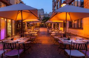 a group of tables with umbrellas on a street at Les Jardins Du Marais in Paris