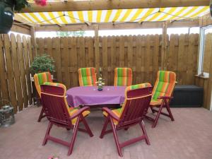 a purple table with four chairs and a fence at Ferienwohnung Rogge (Stendal) in Wittenmoor