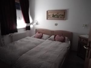 een slaapkamer met een bed met 2 roze kussens bij Apartments Cableway Canazei in Canazei