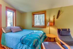 a bedroom with a bed and a chair and a window at Island Artist Studio in Orcas
