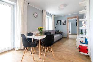 ein Wohnzimmer mit einem Tisch, Stühlen und einem Sofa in der Unterkunft Leśna#46 in Olsztyn