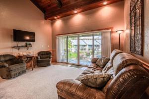 a living room with a leather couch and a television at Condo Del Sol 210 in Sandpoint