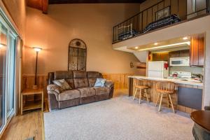 a living room with a couch and a kitchen at Condo Del Sol 210 in Sandpoint