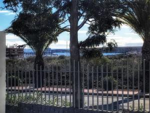 a fence with trees and a view of the ocean at Oasis Costa del Silencio - Large Pool & Relax in Costa Del Silencio +13 photos