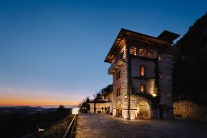 a building on a hill with the sunset in the background at Tenuta De L'Annunziata - Natural Relais in Uggiate