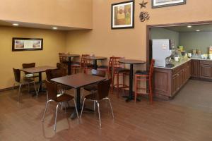 a restaurant with tables and chairs and a kitchen at Quality Inn in Gonzales