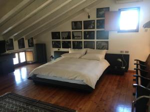 a bedroom with a large white bed with pictures on the wall at Terminus in Villastrada