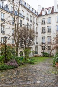 a large building with a stone walkway in front of it at Veeve - Retro Cool on Rue Saint Paul in Paris