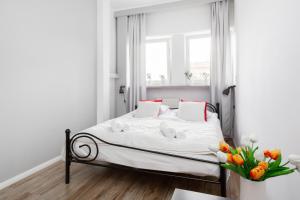 ワルシャワにあるOlivia Apartment by Rentersの白いベッドルーム(窓付きのベッド付)