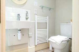 a white bathroom with a sink and a toilet at The Farmhouse at Bodnant Welsh Food in Conwy +40 photos