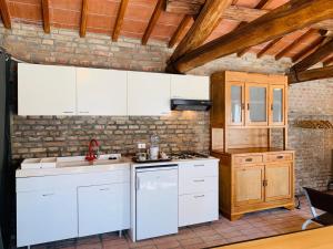 a kitchen with white cabinets and a brick wall at Terminus in Villastrada