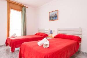 two beds in a room with red sheets at Europa 3B in Port de Pollensa