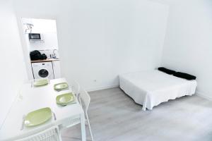 Habitación blanca con cama, mesa y espejo. en Apartamento Malasaña I, en Madrid