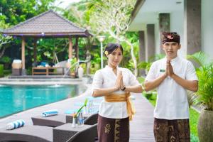 Un paio di persone che fanno yoga in piscina di Ubud Raya Boutique Hotel ad Ubud Altre 37 foto