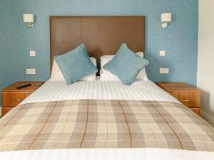 łóżko z dwoma niebieskimi poduszkami na górze w obiekcie King Robert Hotel w mieście Stirling