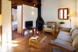 sala de estar con sofá y chimenea en Can Noves - Villa de 2 suites, en Sant Francesc Xavier