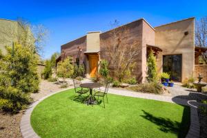 - un jardin avec une table et des chaises en face d'une maison dans l'établissement Casa San Miguel, à Tucson