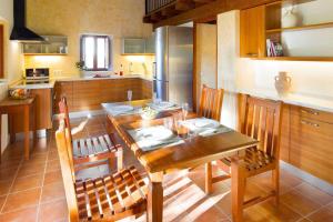 a kitchen with a wooden table and wooden chairs at Can Noves - Villa de 2 suites in Sant Francesc Xavier