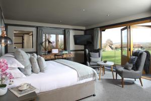 a bedroom with a large bed and a desk and chairs at The Jack Russell in Andover