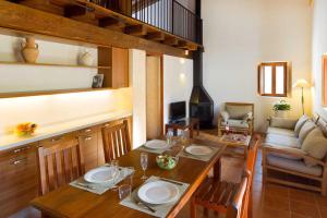 a dining room with a table and a living room at Can Noves - Villa de 2 suites in Sant Francesc Xavier