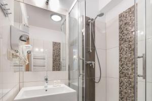 Borowy Dwór- Biznes, Spa & Fun في شافلاري: حمام أبيض مع حوض ودش