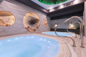 Borowy Dwór- Biznes, Spa & Fun في شافلاري: حمام به حوضي استحمام ساخن ومرايا دائرية