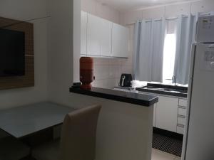 a kitchen with white cabinets and a black counter top at Apartamento Cidade Verde 7 MT in Maringá