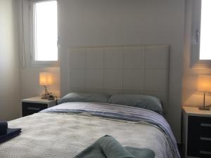 a bedroom with a bed with two lamps on both sides at Apartamento Aqua Nature Delfin in La Mata +19 photos